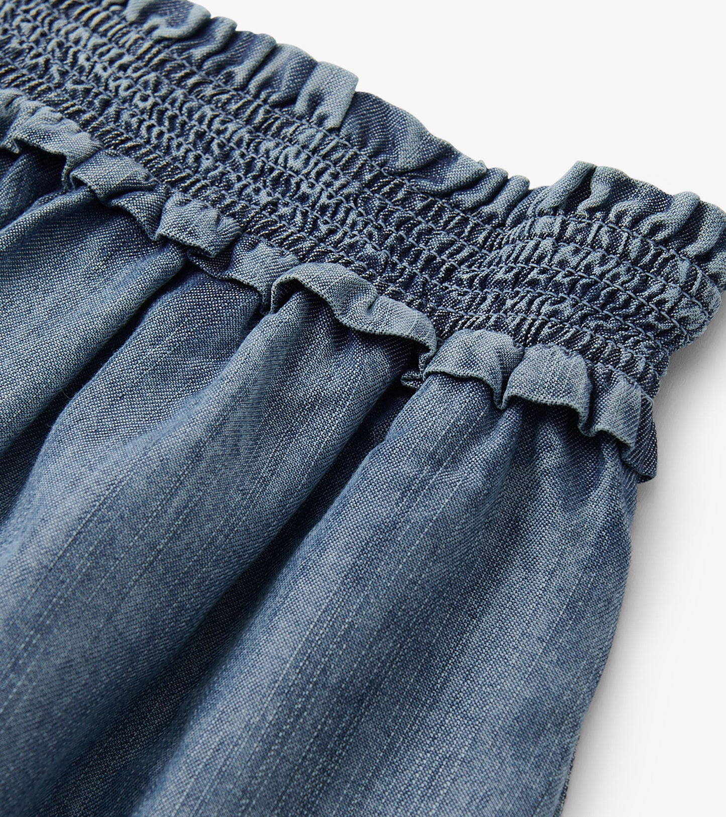 Blue acid wash layered smocked skirt with a ruffled waistband, showcasing a soft, lightweight fabric.