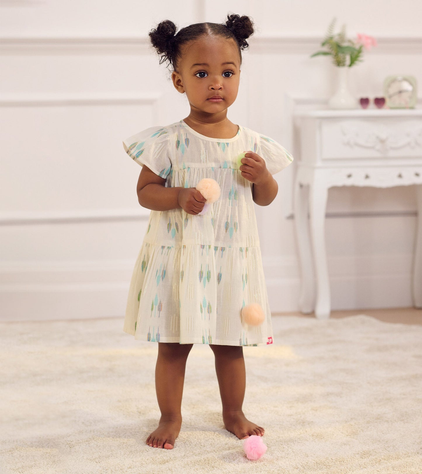 Light blue woven puff dress with feather patterns, short flutter sleeves, and a tiered design, suitable for baby and toddler…