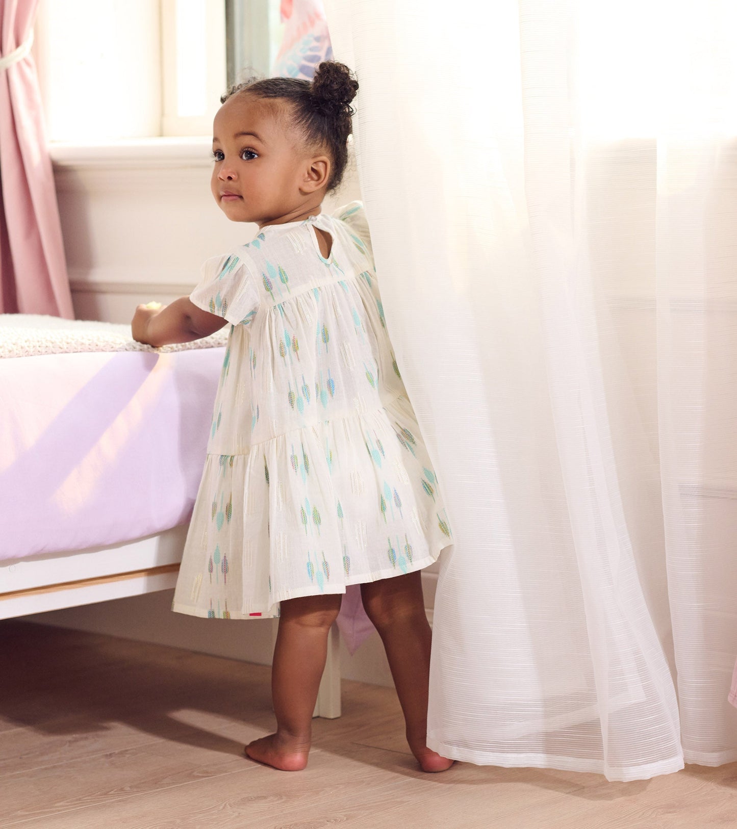 Blue feather pattern woven puff dress with short sleeves and a keyhole back, worn by a toddler girl.