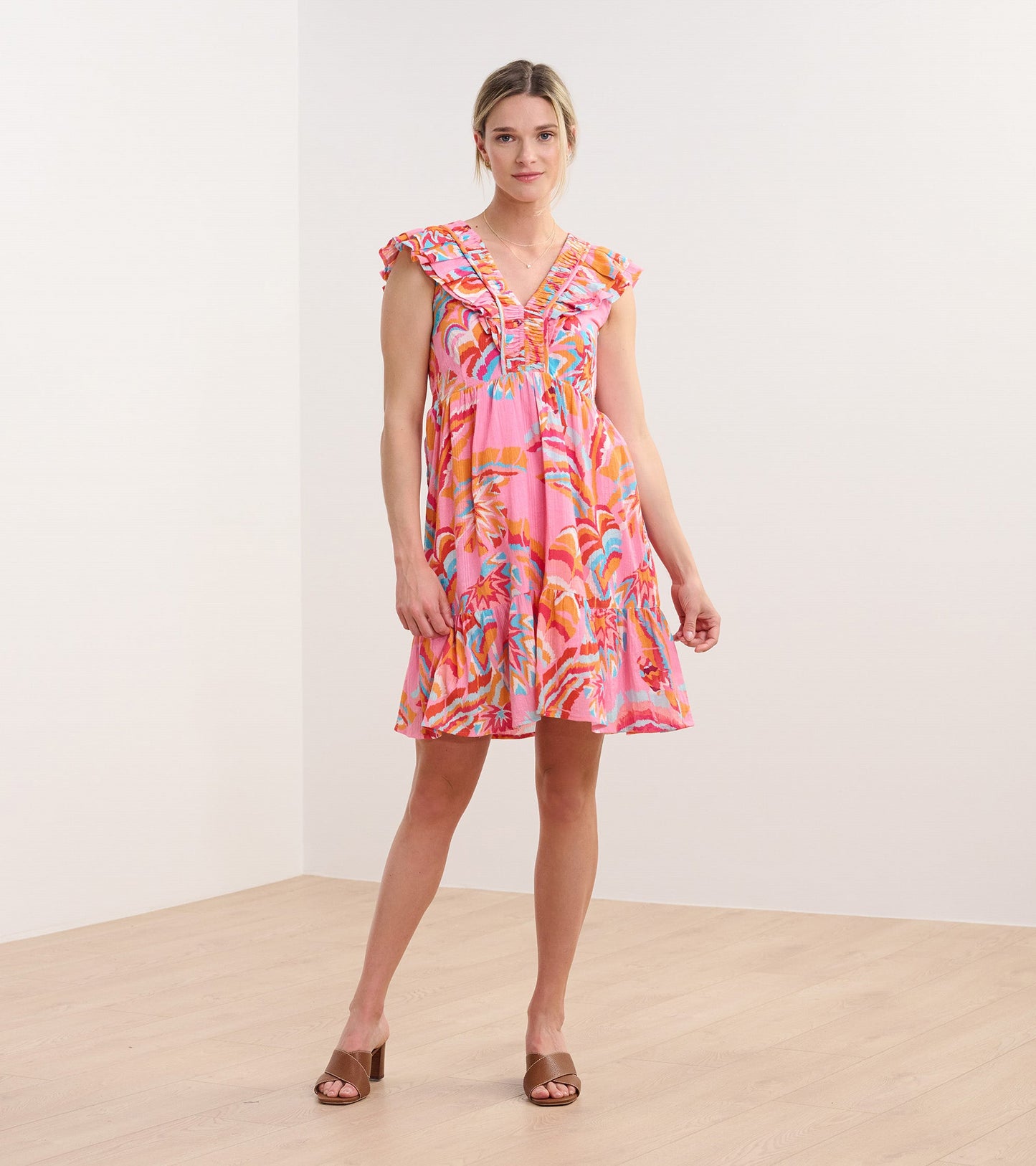 Pink dress with ruffle sleeves and a tropical floral pattern, featuring a V-neck and a flared silhouette.