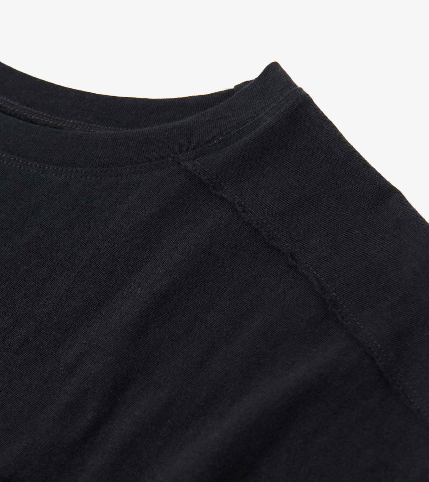 Black slouchy tee with a round neckline and visible stitching detail, made from soft fabric.