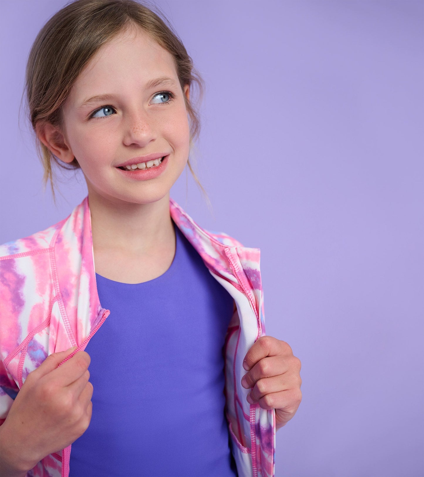 Ombre pink and white active jacket with a zip front, worn over a purple top, suitable for girls.