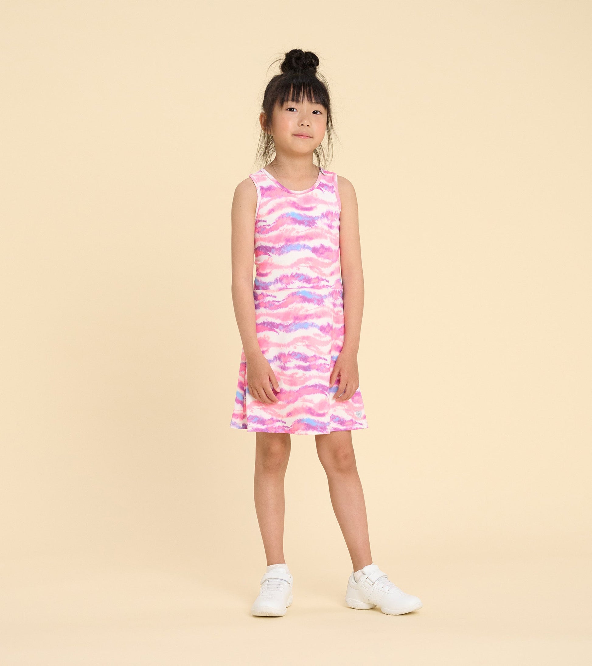 Sleeveless A-line dress in pink ombre pattern, perfect for active play, worn by a girl with white sneakers.