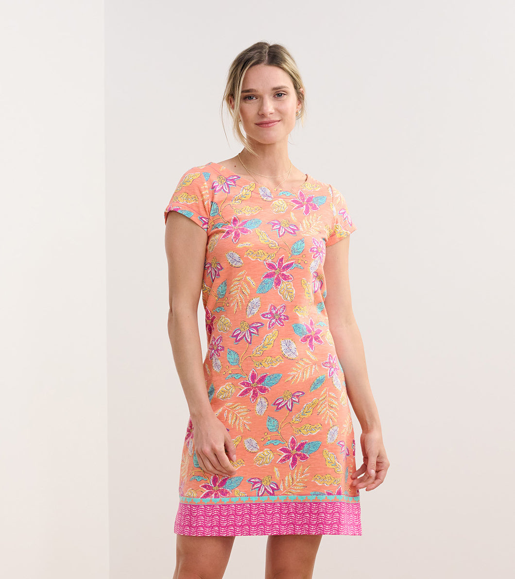 Short-sleeve dress in coral with a distressed floral pattern in pink, blue, and green, featuring a patterned hem.