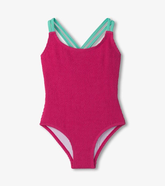 Fuchsia purple cross strap swimsuit with textured fabric and mint green straps, ideal for swimming.