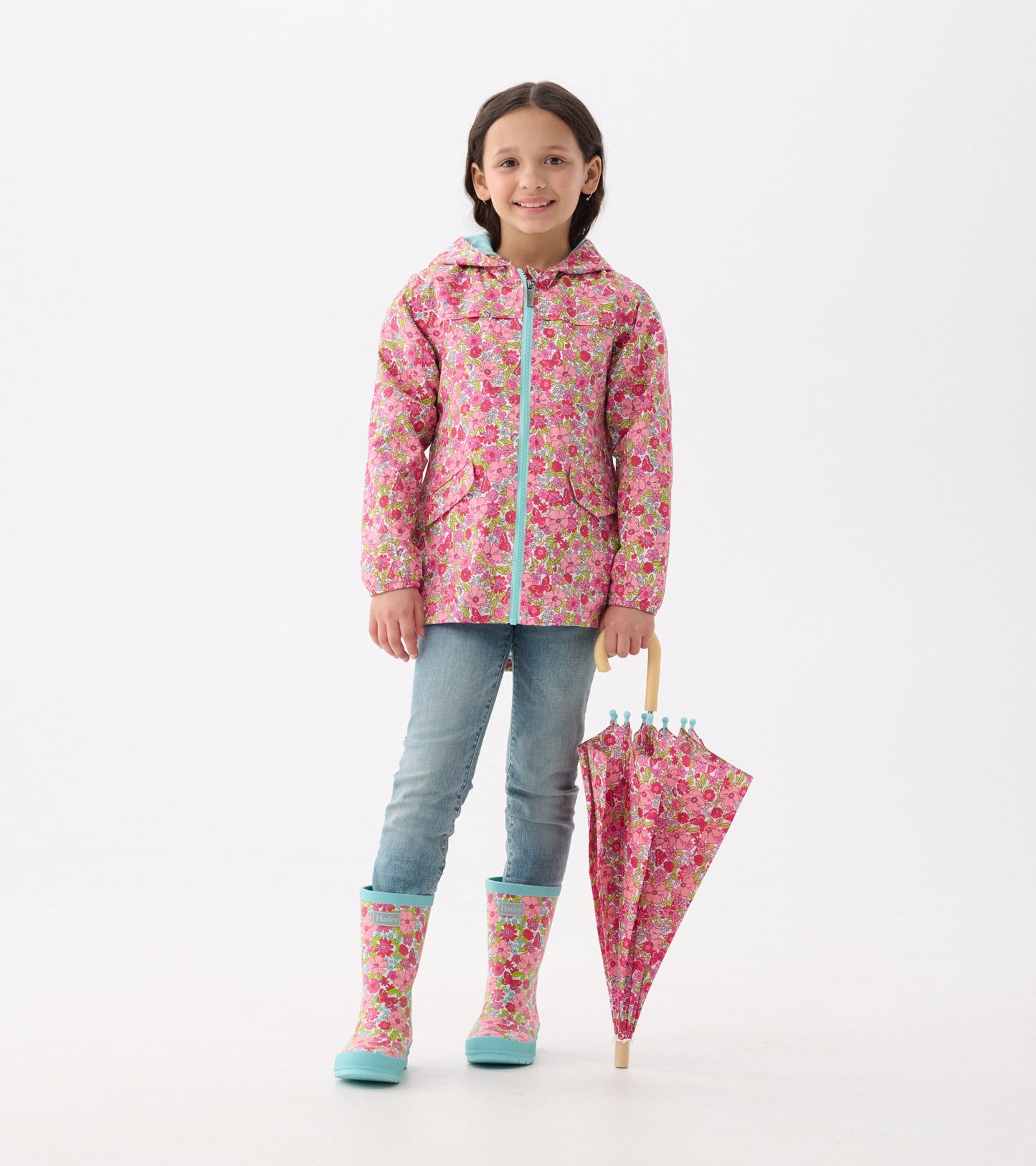 Matte rain boots in pink with a groovy flower pattern and turquoise trim, perfect for rainy days.