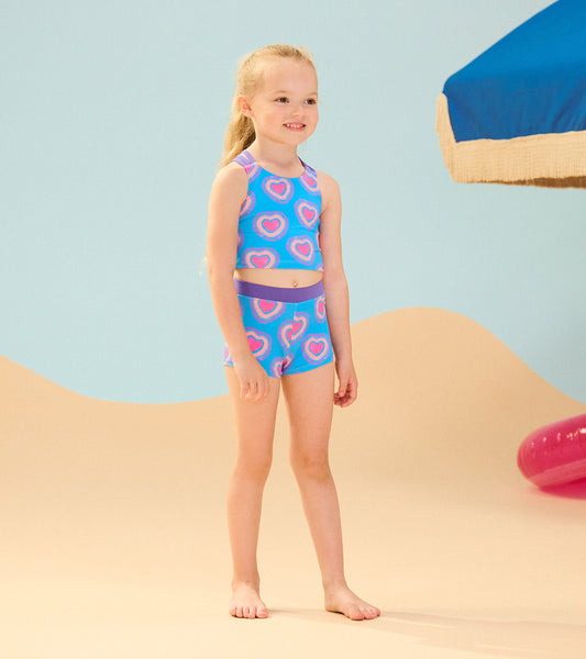 Two-piece short swimsuit featuring a blue background with pink glowing hearts, ideal for beach or pool wear.