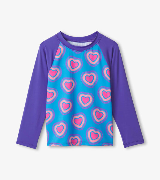 Long sleeve rashguard featuring a blue body with pink and purple heart patterns and purple sleeves.
