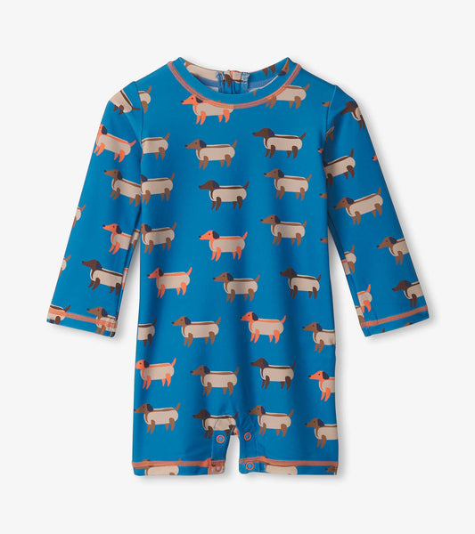 Blue one-piece rashguard featuring a playful hot dog pattern, long sleeves, and snap closures at the bottom.