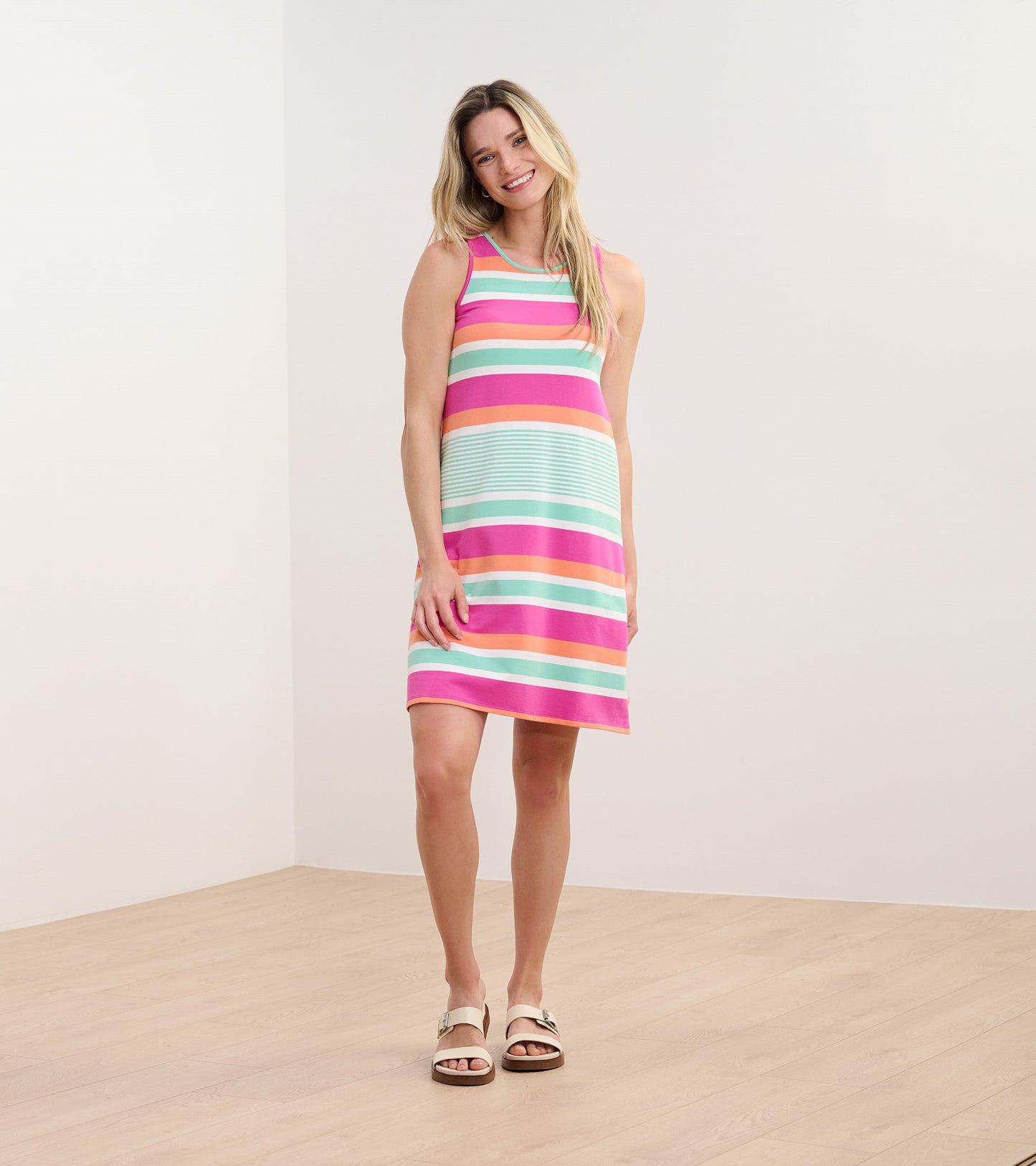 Sleeveless dress in hot fuchsia with colorful stripes, featuring a relaxed fit and knee-length design.