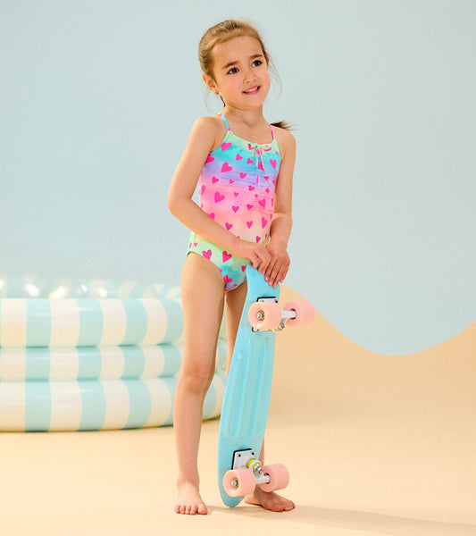 Colorful swimsuit featuring a ruched front with a kaleidoscope of hearts, perfect for summer fun by the pool.