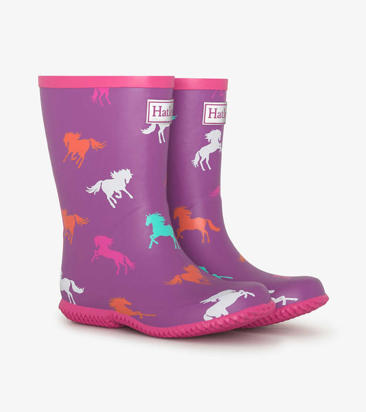 Purple rain boots featuring colorful leaping horses, with a pink trim and textured sole for grip.