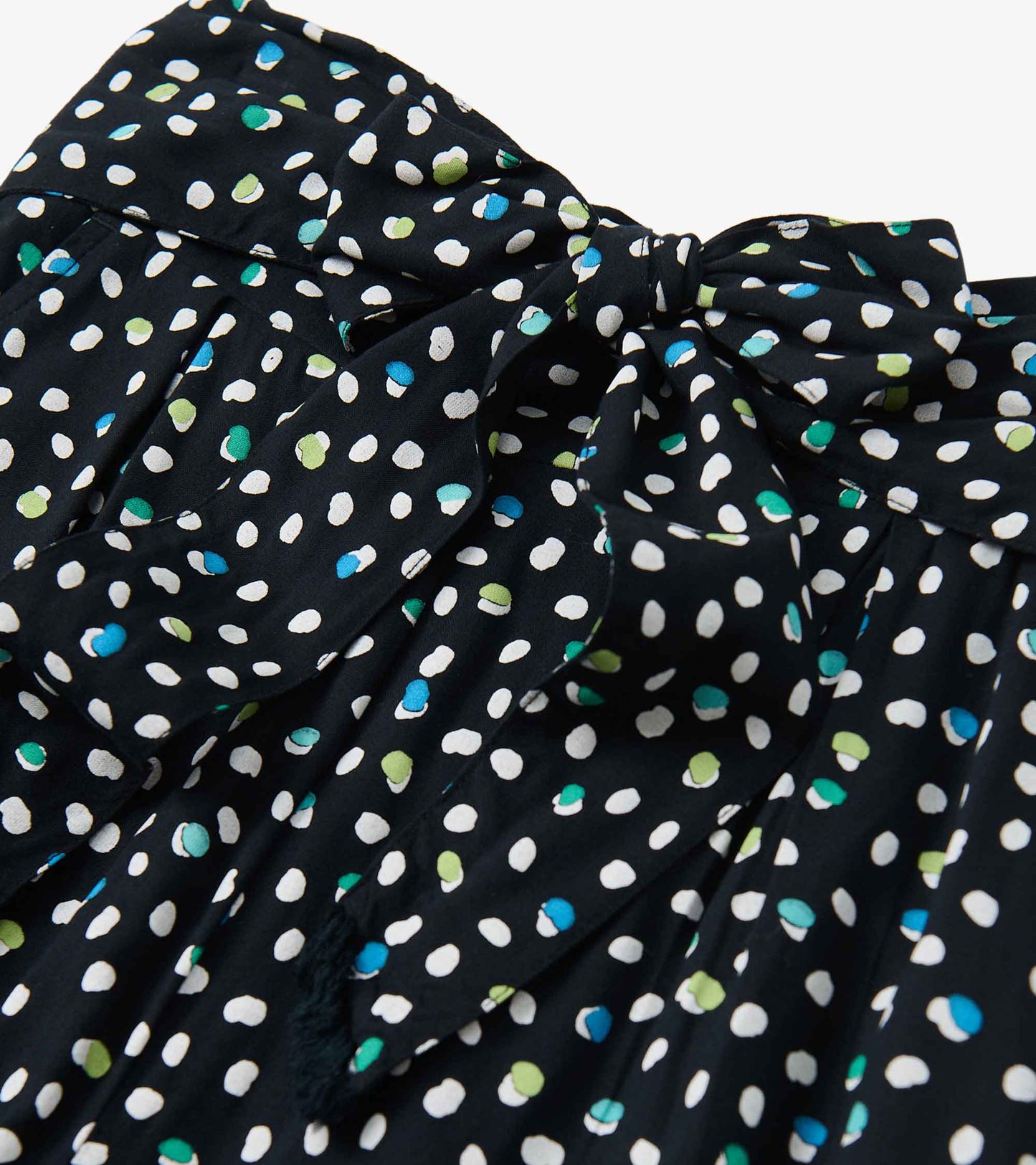 Belted wide leg pants featuring a black fabric with colorful polka dots in white, green, and blue.