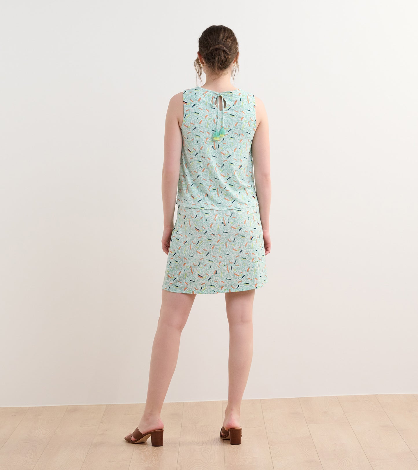 Light blue sleeveless dress with a leaf pattern, featuring a tie back and a flared skirt.