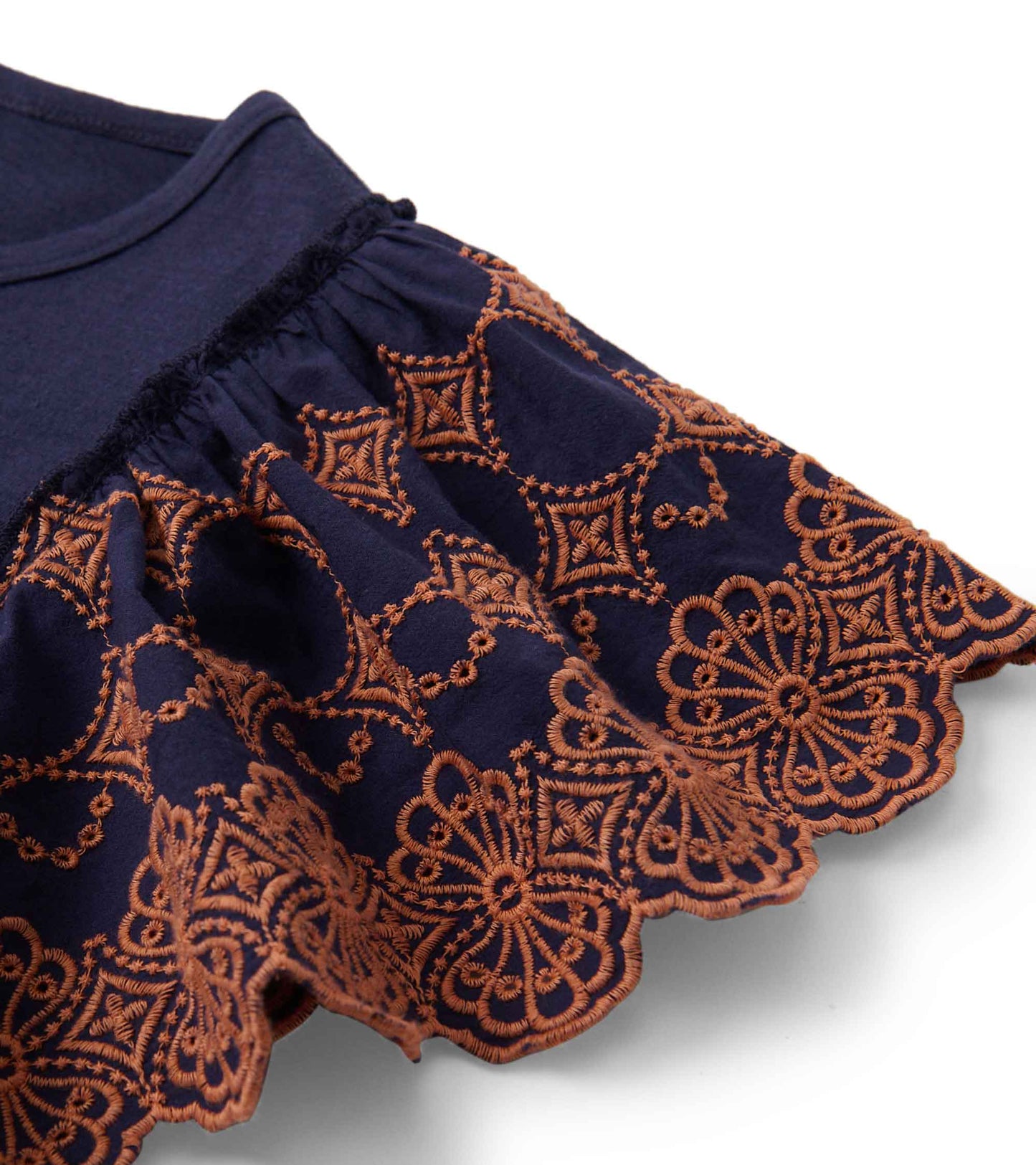 Patriot blue tank top featuring eyelet sleeves with intricate orange embroidery along the hem.
