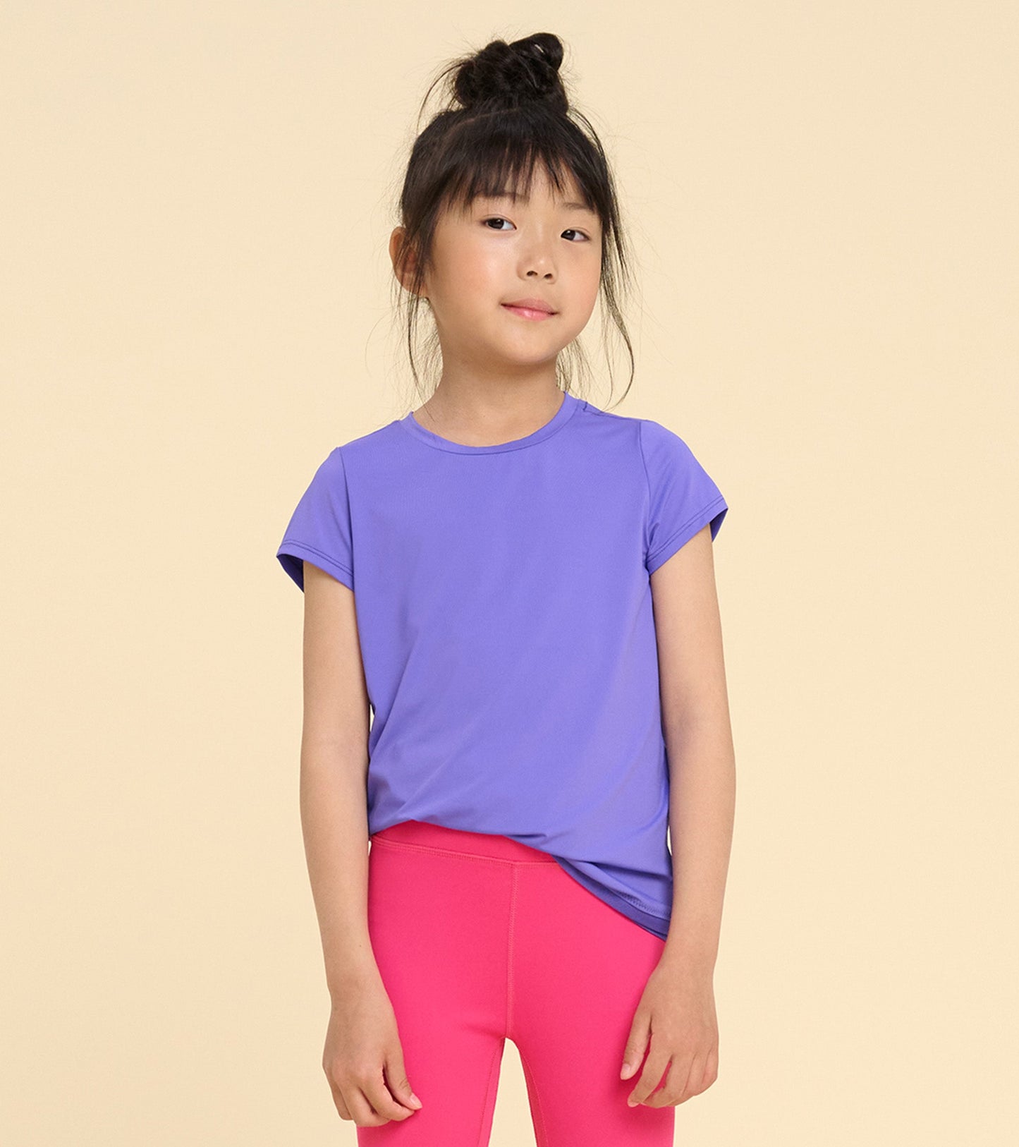 Purple short-sleeve T-shirt with a smooth mesh trim, worn with pink leggings, suitable for casual wear.
