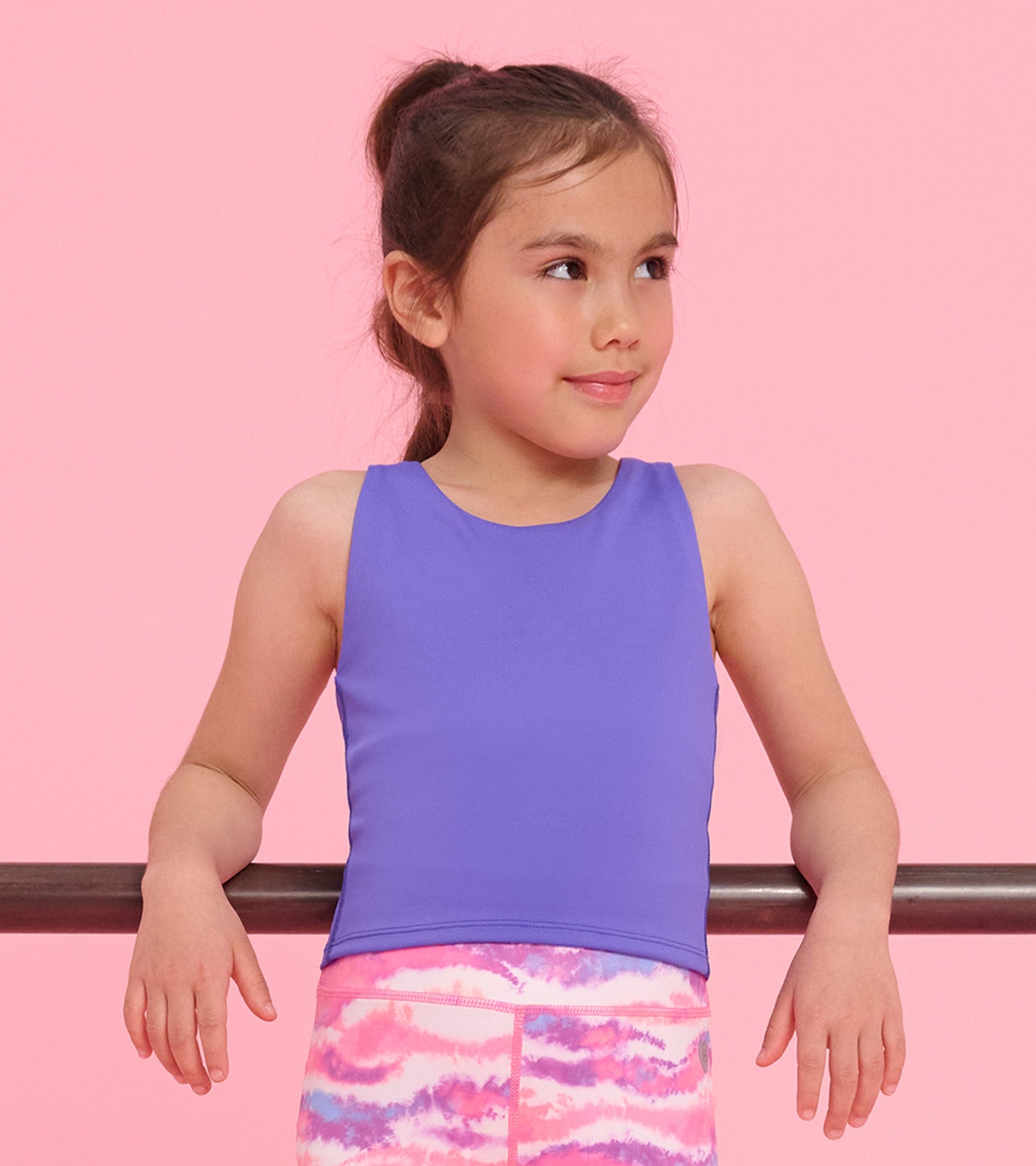 Purple tank top with a round neckline, worn by a girl, paired with colorful patterned leggings.