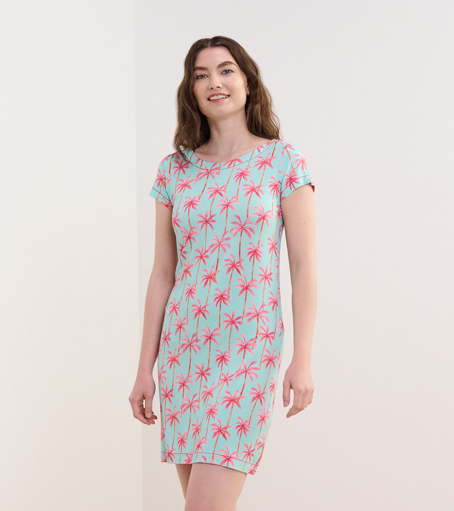 Short-sleeve dress in light blue with a pink palm tree pattern, featuring a relaxed fit and round neckline.
