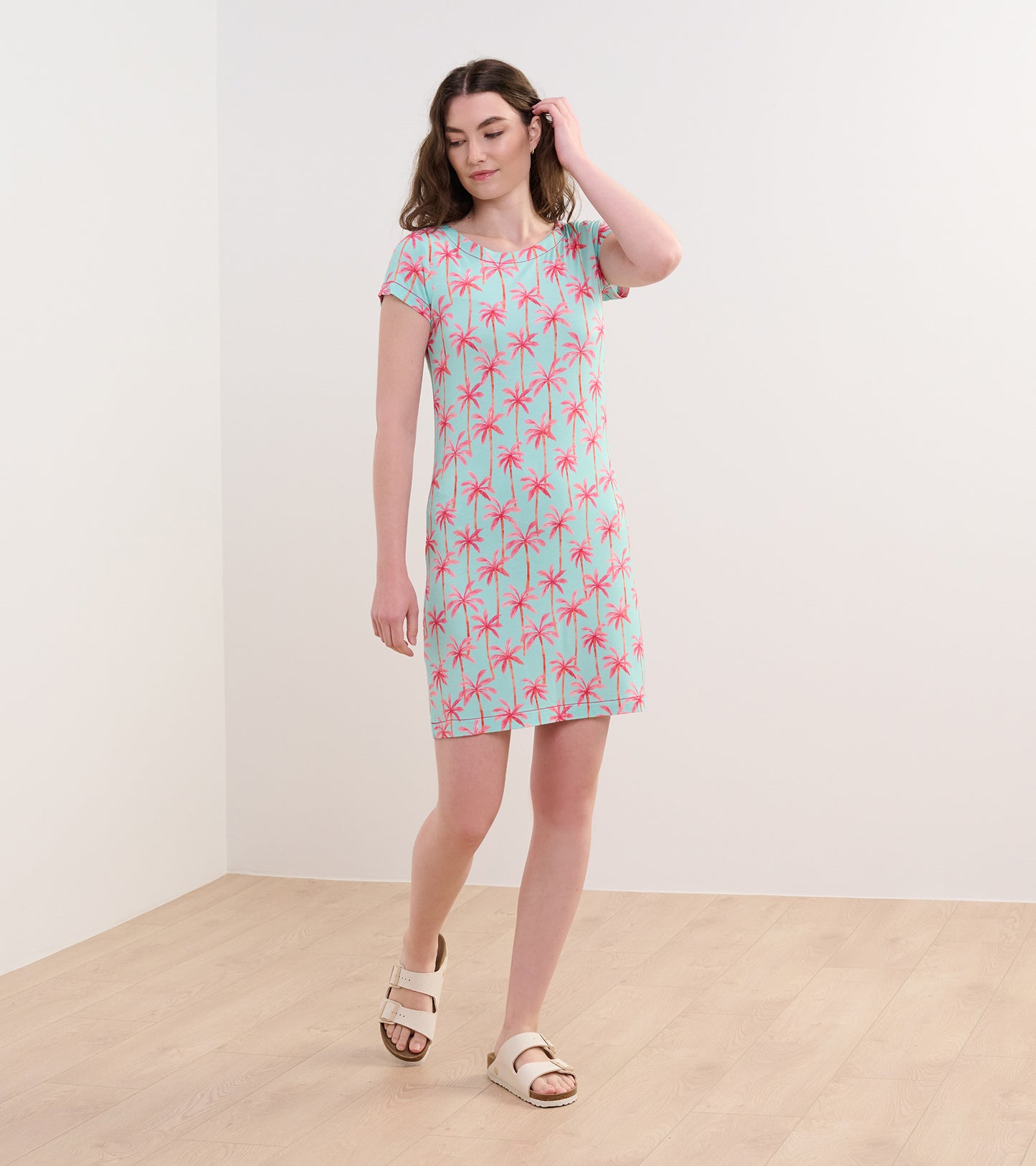 Short-sleeve dress featuring a light blue background with pink palm tree print, perfect for casual summer wear.