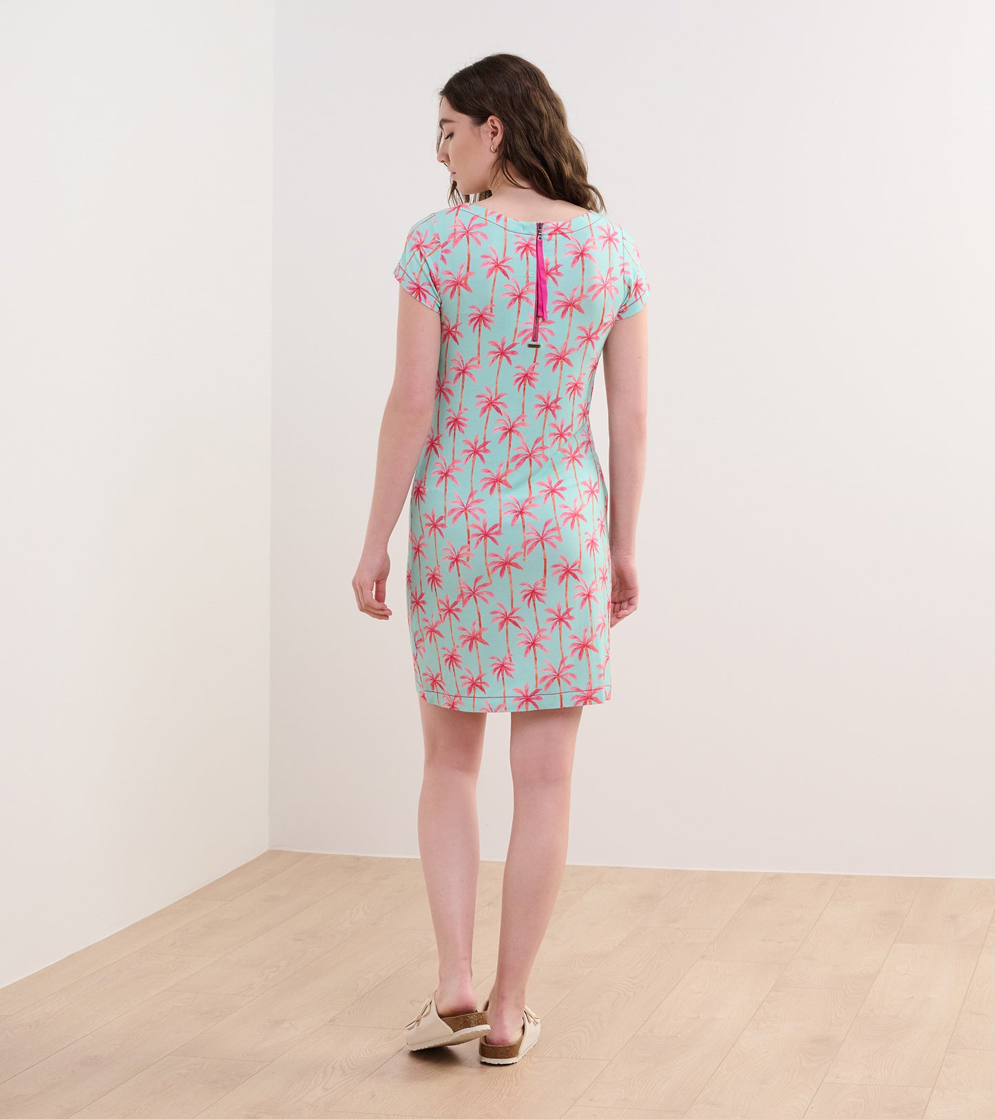 Short-sleeve dress in light blue with pink palm tree pattern, featuring a back zipper and a fitted silhouette.