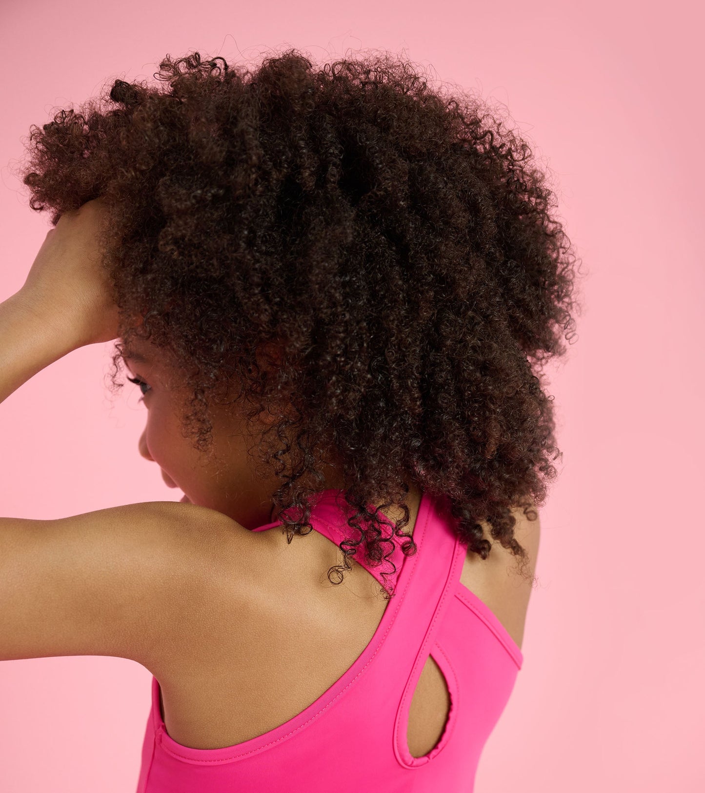 Pink A-line dress with a racerback design, suitable for active wear, shown from a side angle.