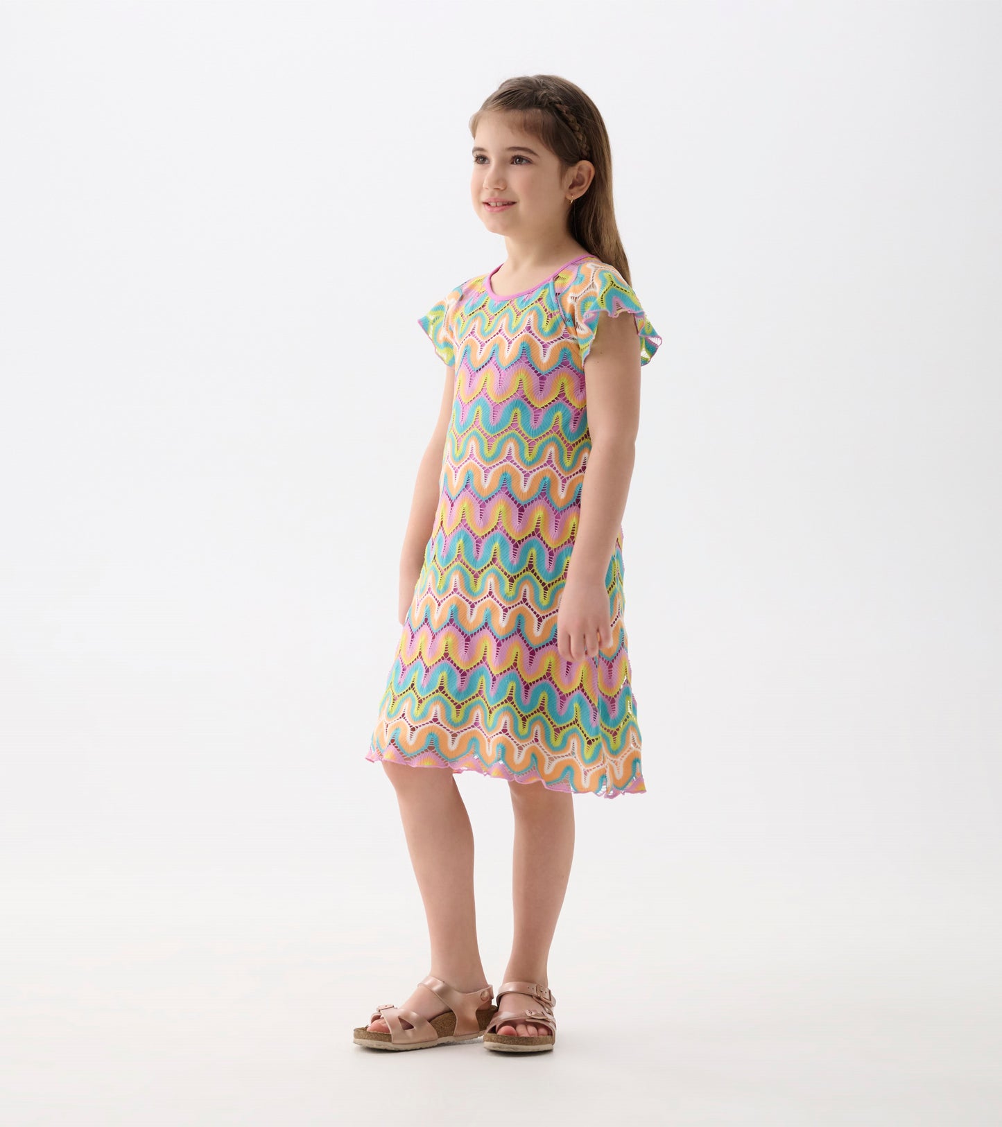 Colorful crochet dress featuring a wavy pattern in pink, green, and blue, with short flutter sleeves and a knee-length cut.
