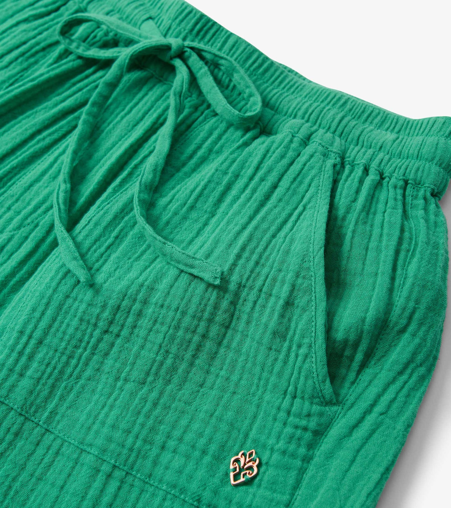 Sea green shorts with a textured fabric, elastic waistband, and drawstring, featuring side pockets.