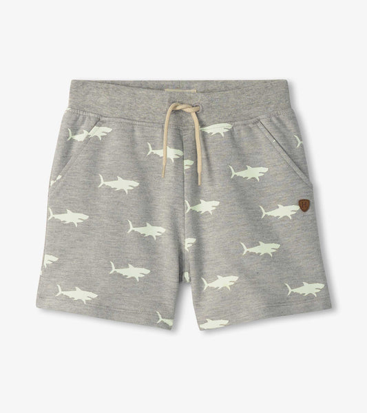 Gray pull-on shorts featuring glow-in-the-dark shark patterns and an elastic waistband with a drawstring.