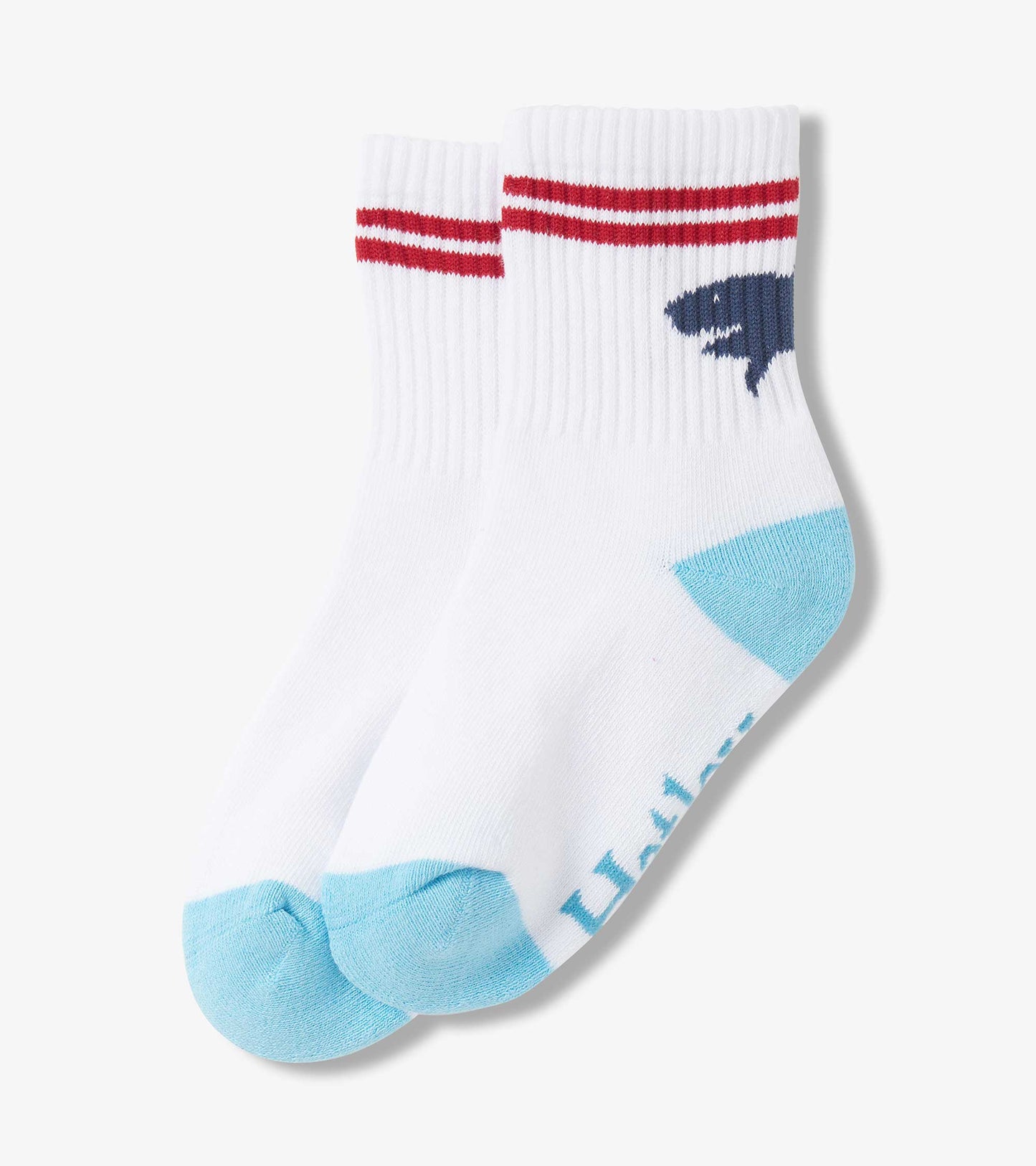 White crew socks featuring a shark silhouette, red stripes at the top, and light blue accents on the toes.