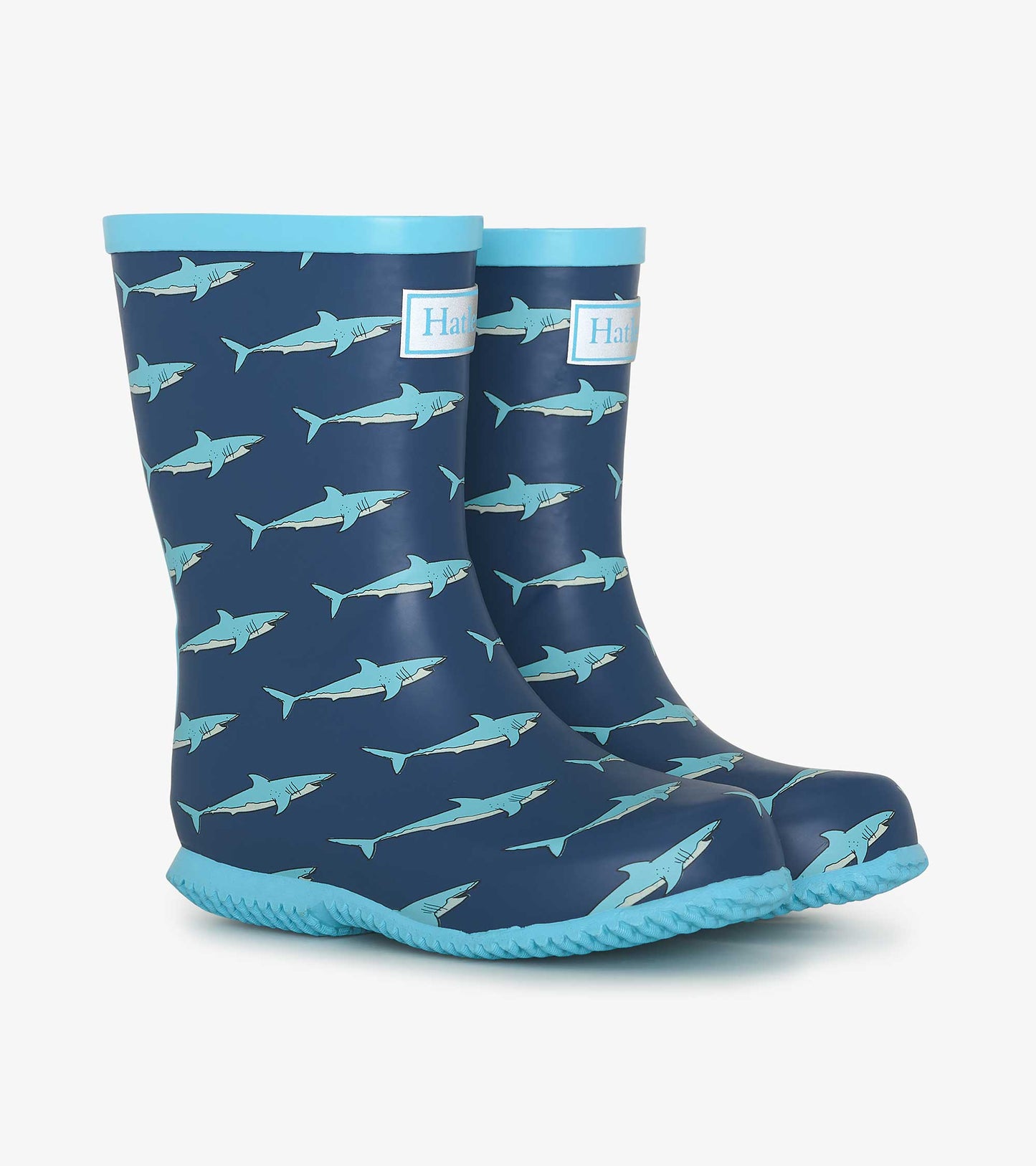 Navy rain boots featuring a shark pattern, with a light blue trim and textured soles for grip.