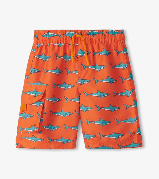 Orange board shorts featuring a playful shark pattern, with an elastic waistband and side pocket.