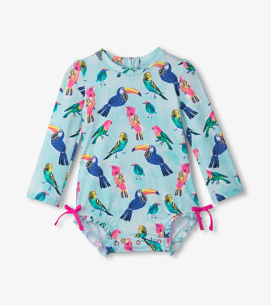 Light blue long-sleeve rashguard swimsuit featuring colorful tropical birds and pink ties at the legs.