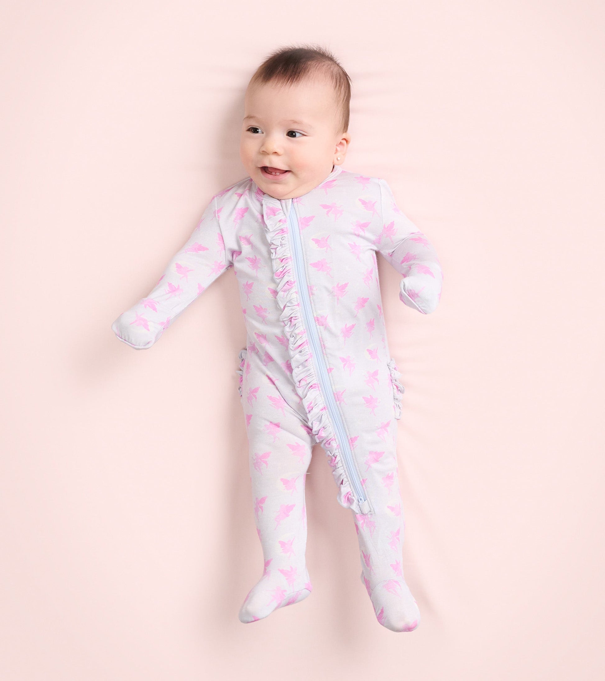 Light gray footed sleeper with pink fairy print and ruffle detail, designed for baby girls.