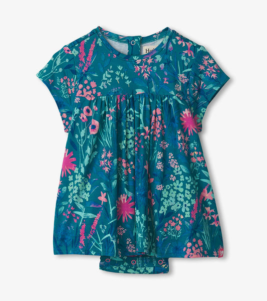 Teal one-piece dress with vibrant wildflower print, short sleeves, and snap closure at the bottom for easy dressing.