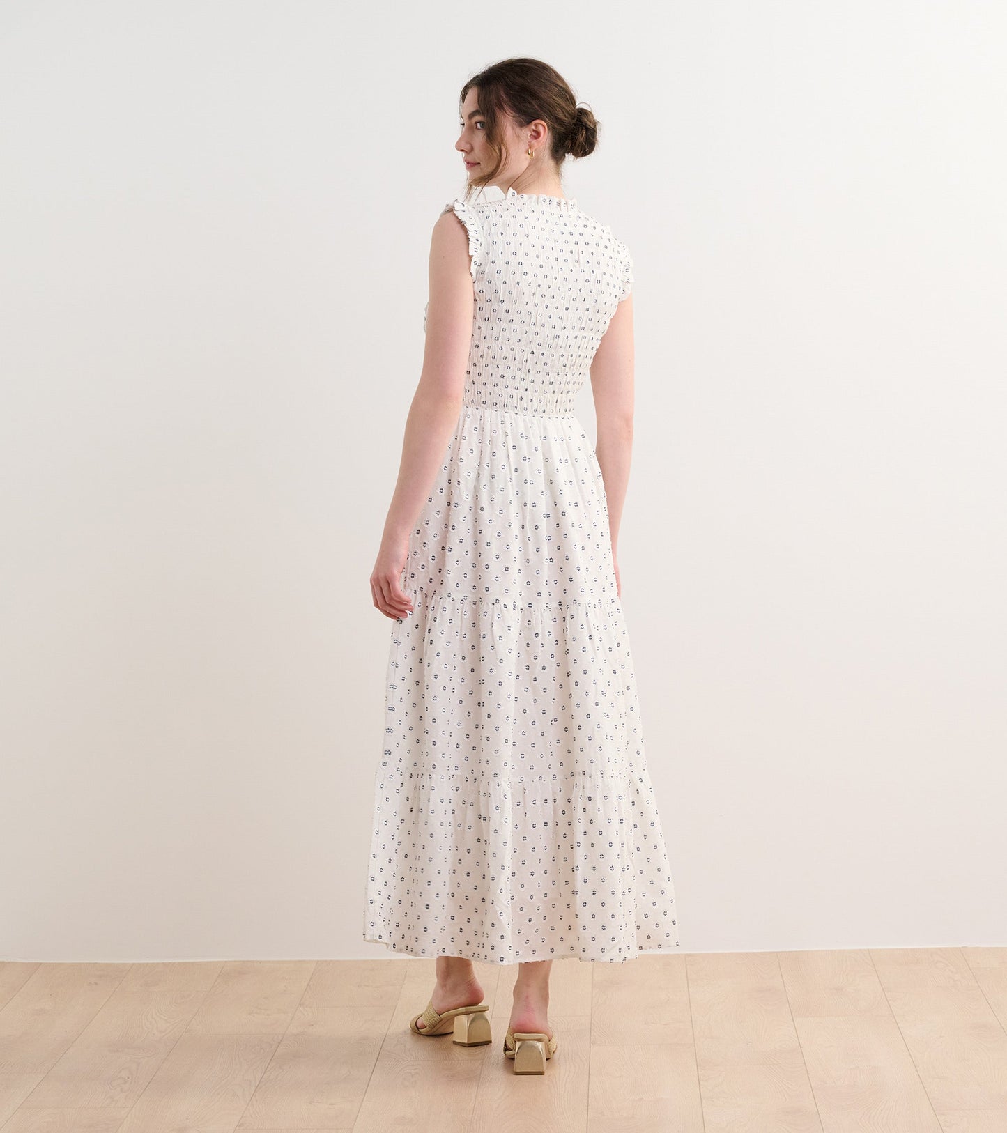 Navy spotted smocked maxi dress with ruffled sleeves and tiered skirt, shown from the back.