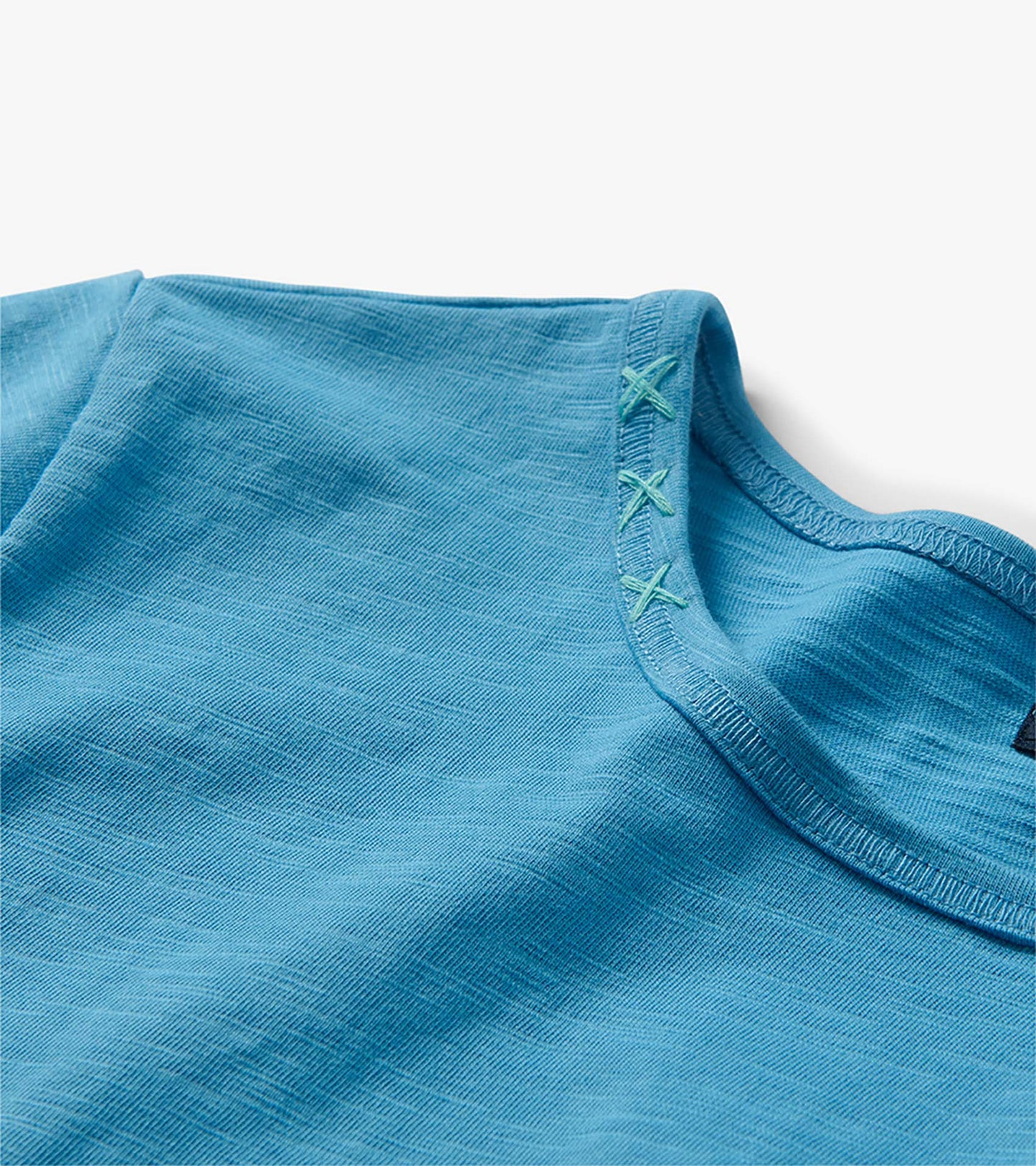 Close-up of the azure midi T-shirt dress neckline with contrast X stitching detail