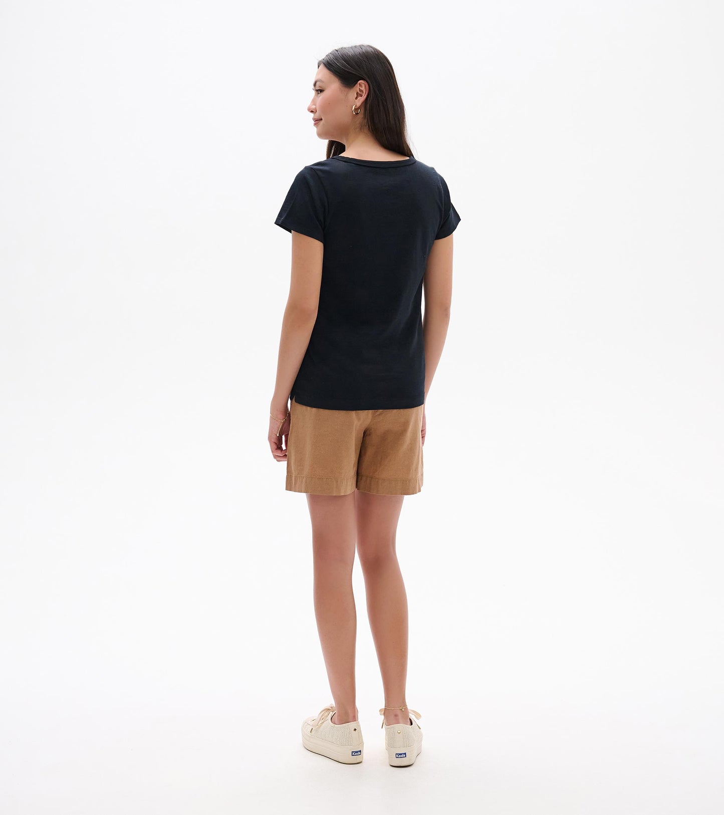 Back view of a black crew neck short-sleeve tee on a model, with a slim fit and straight hem