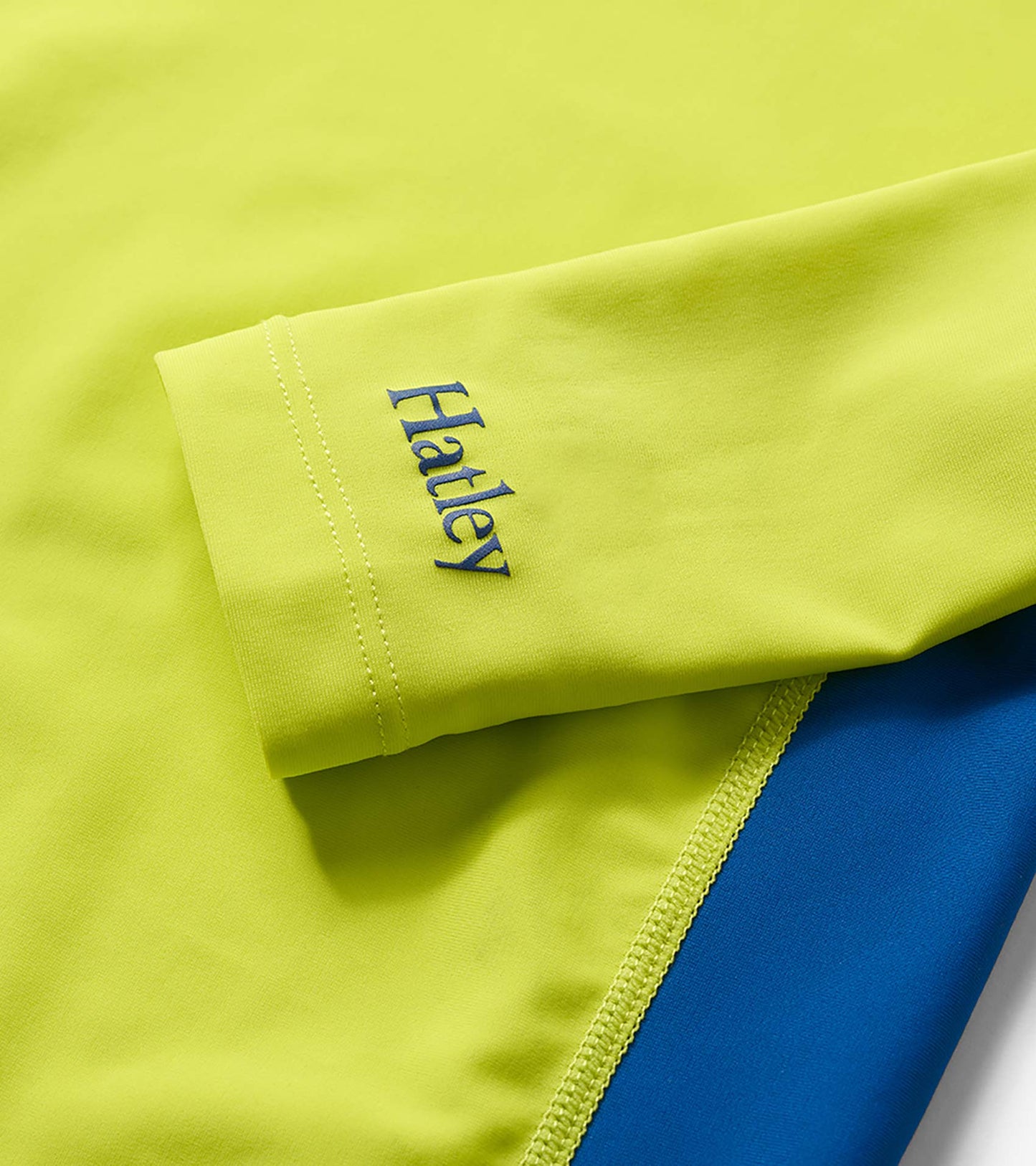 Lime and blue colorblock long-sleeve rashguard with stitched cuff detail and logo print