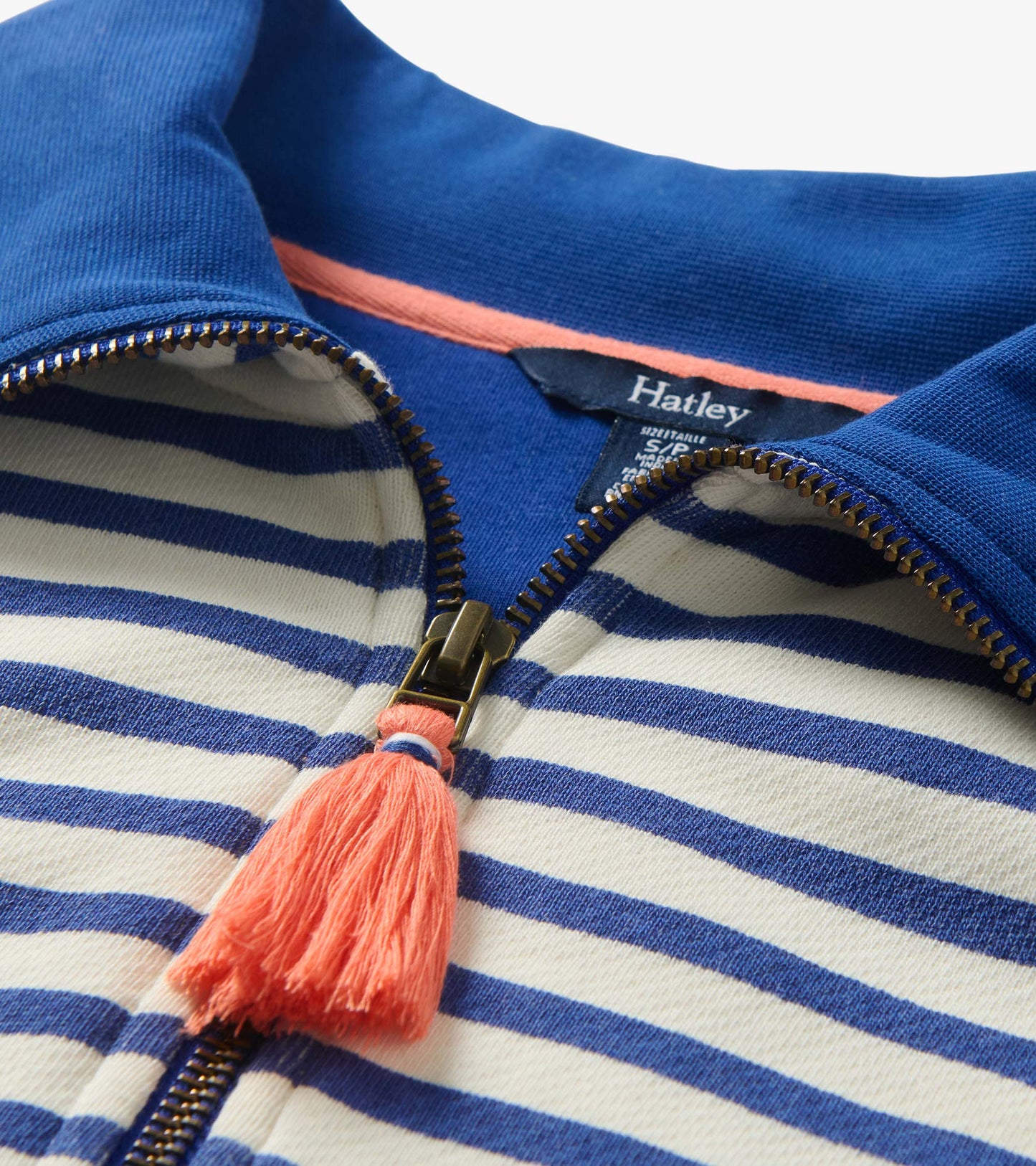 Close-up of quarter-zip mock neck with blue collar, striped fabric, and coral tassel zipper pull
