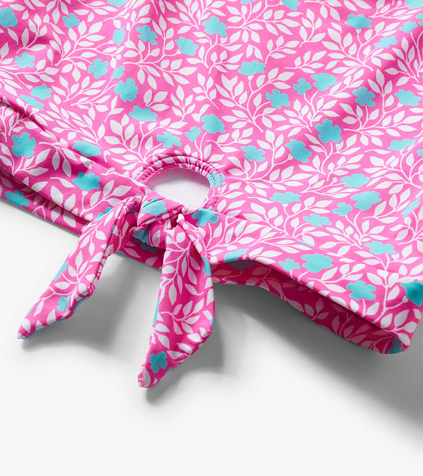 Pink floral and white leaf print girls swimsuit bottom with tie-front detail and cutout opening