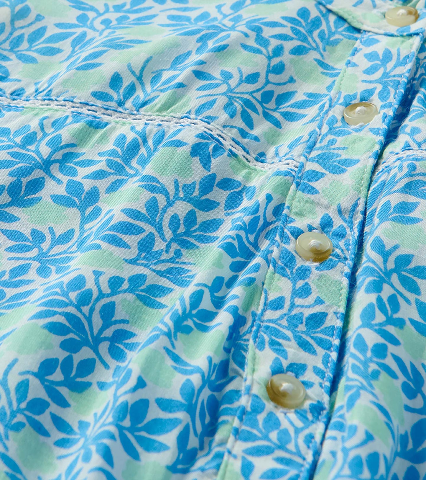 Close-up of blue and soft green mini vine print with button placket and decorative stitching
