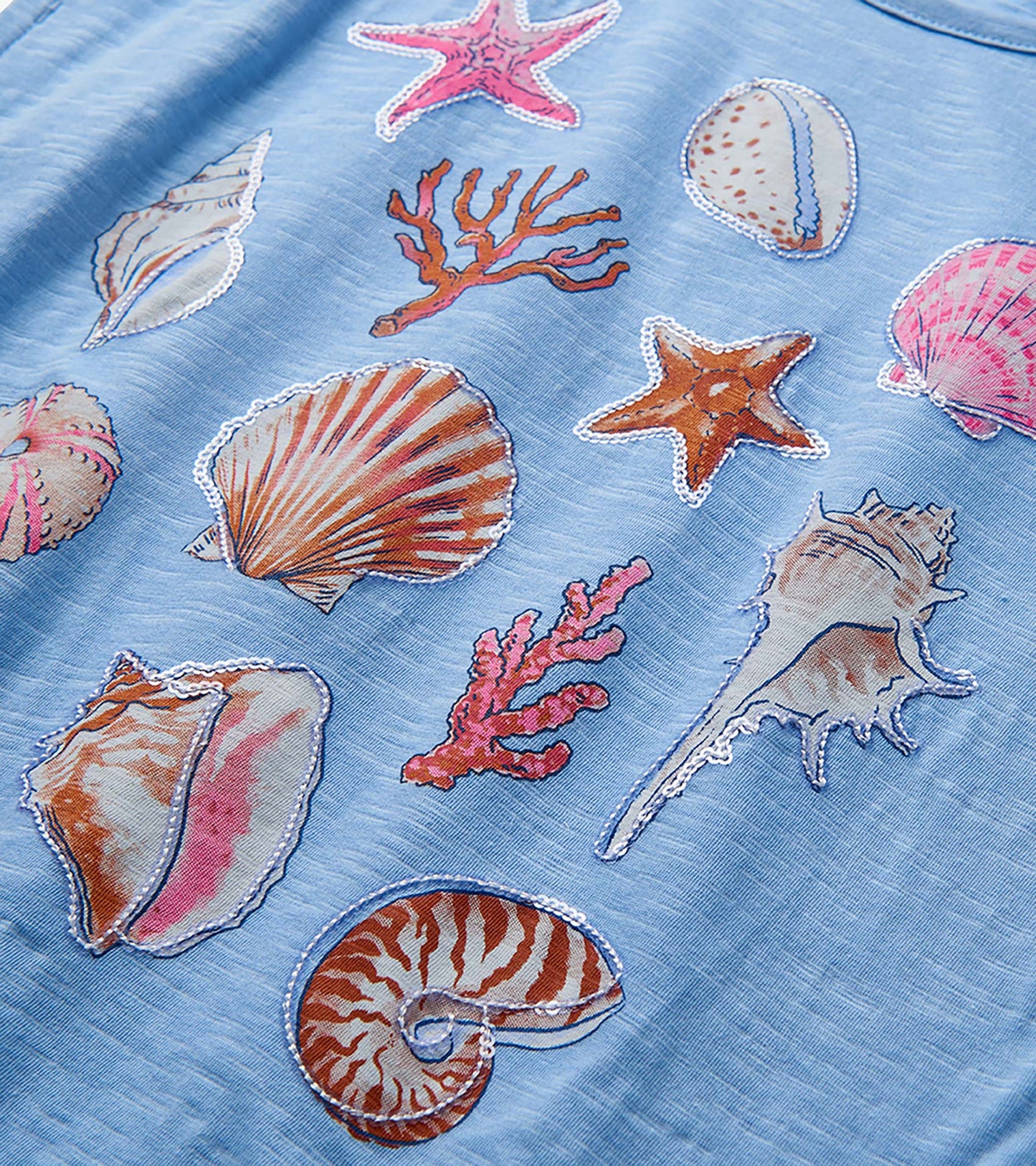 Light blue girls top with colorful seashell and starfish print close-up