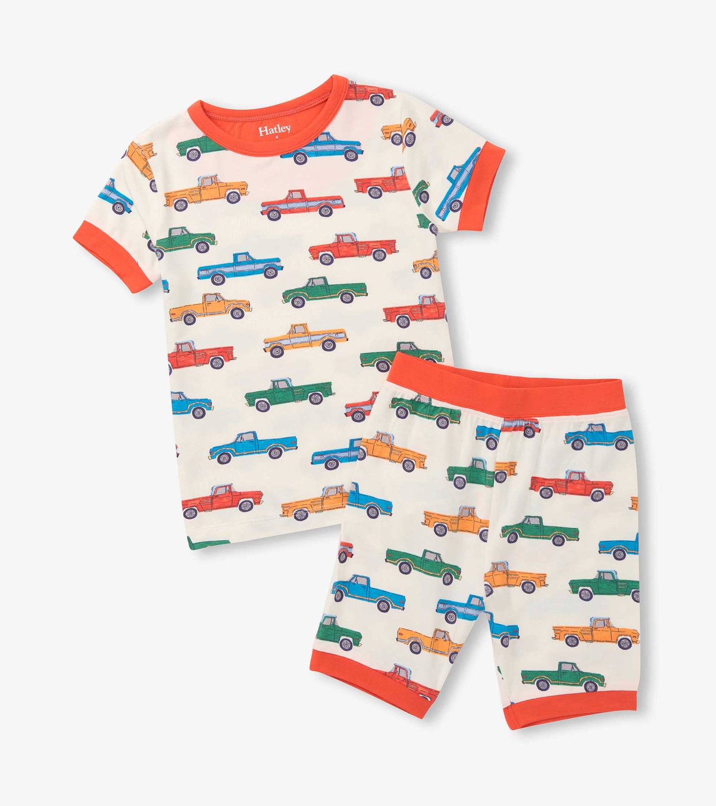 Cream short pajama set with colorful pickup truck print and bright orange trim on sleeves, waistband, and hems