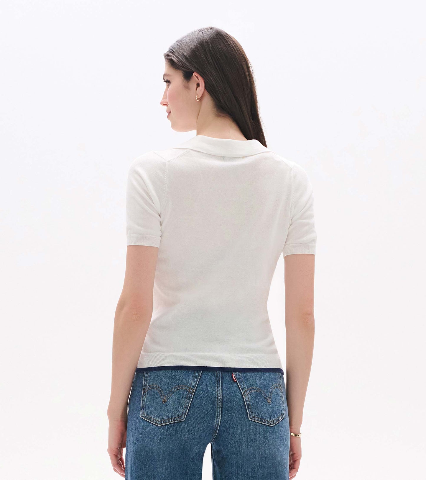 Back view of a white short-sleeve knit polo top with a collar and fitted silhouette