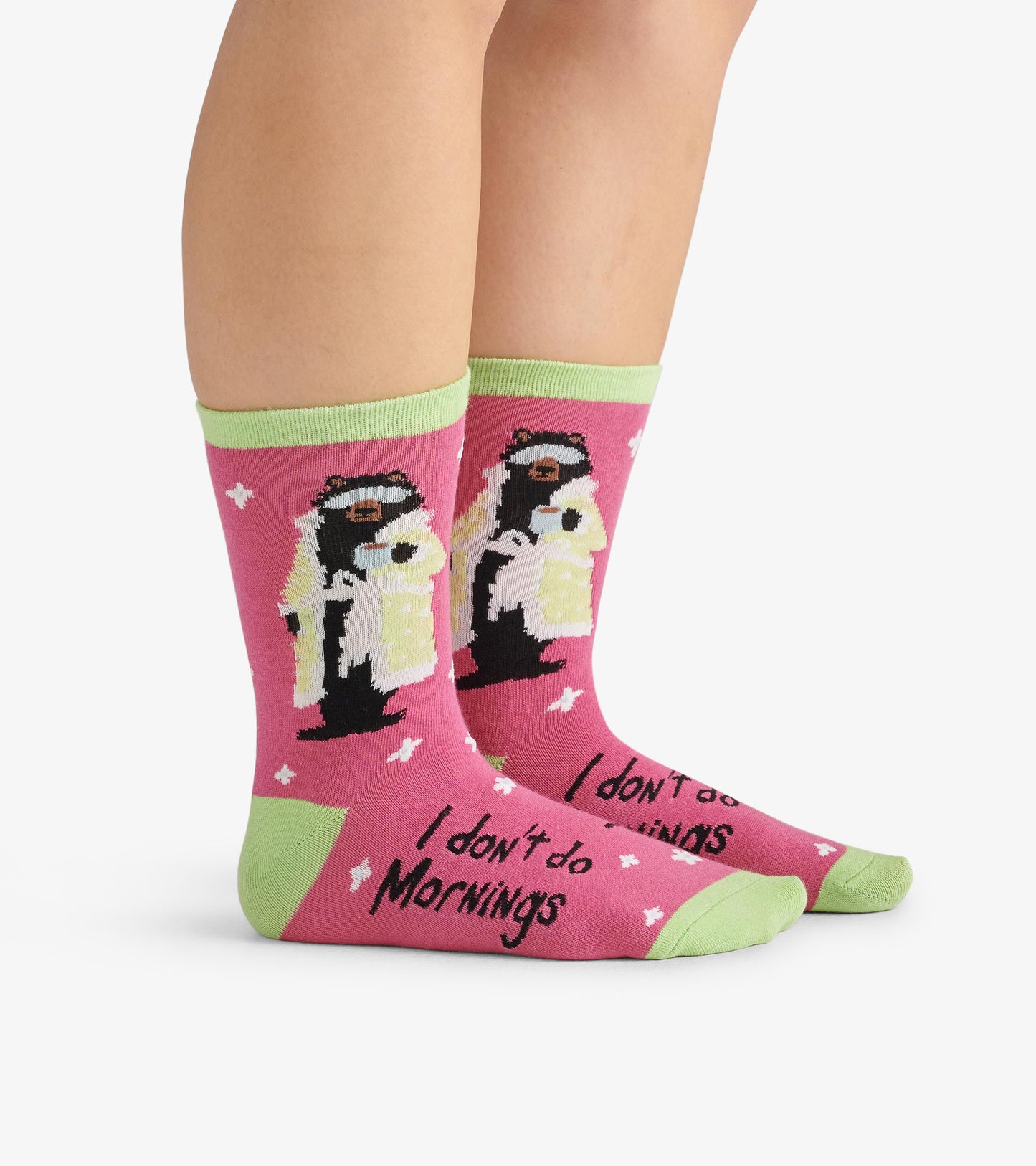 Pink crew socks featuring a bear in a robe holding a coffee cup, with green accents and the text "I don't do Mornings.