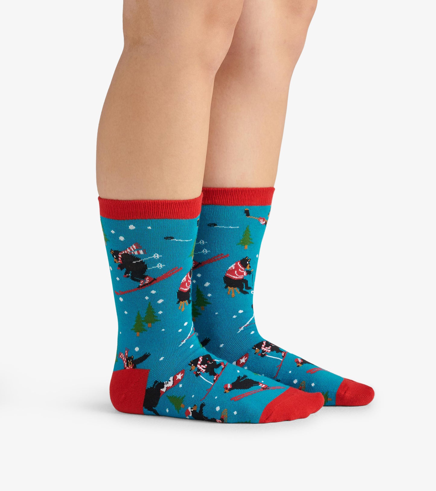Turquoise crew socks with red cuffs, featuring playful winter-themed patterns of bears skiing and trees.