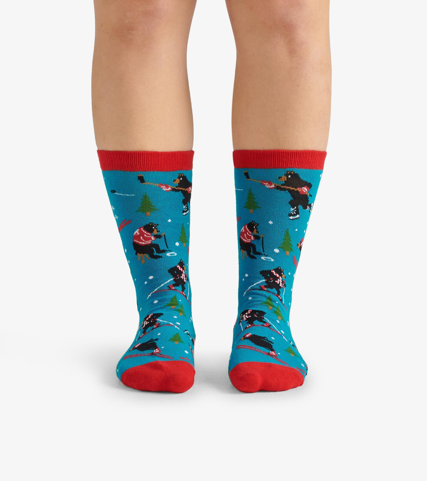 Blue crew socks featuring playful winter scenes with red accents and patterns of dogs and trees. One size fits all.