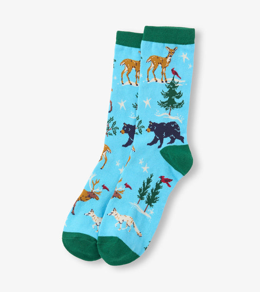 Light blue crew socks featuring winter wildlife patterns, including deer, bears, and trees, with green cuffs.