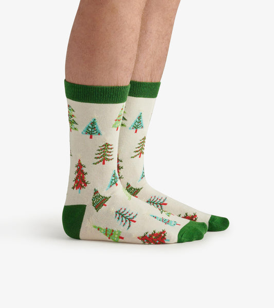 Cream socks featuring colorful Christmas tree patterns and green cuffs and toes, worn on feet.