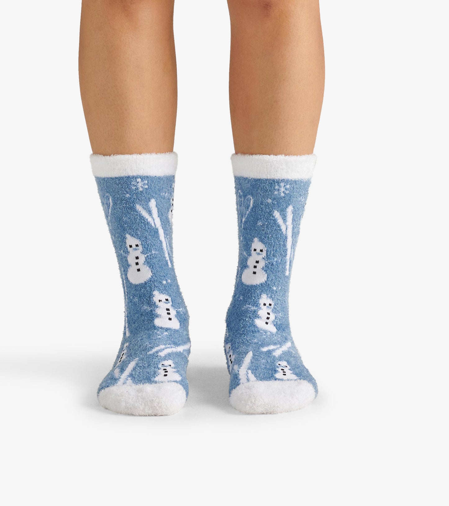 Fuzzy blue socks featuring white snowmen and winter patterns, with a soft white cuff and plush material.
